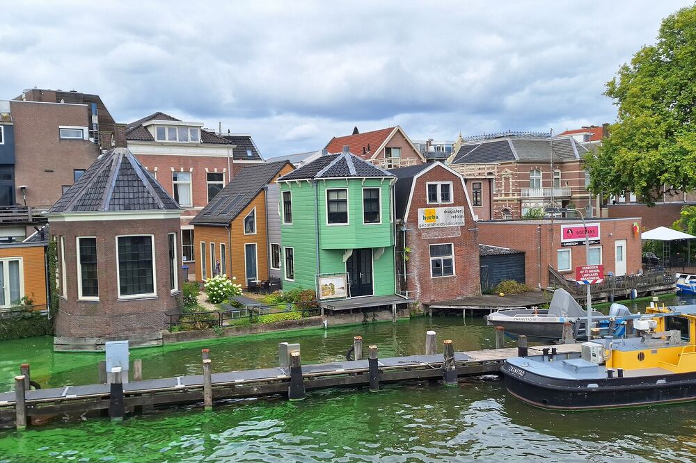 Kleurrijke Zaanse houten huizen aan het water van de Achterzaan in Zaandam